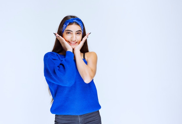 Chica en camisa azul dando poses neutrales y alegres.