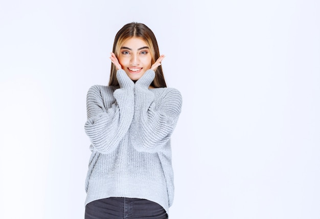 Chica en camisa gris dando poses bonitas y neutrales.