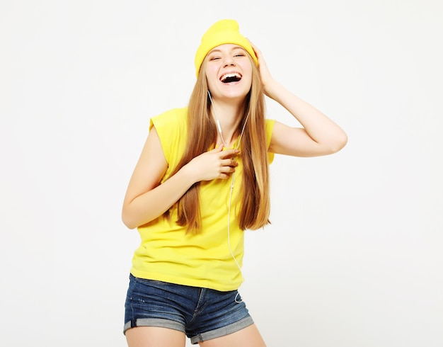 Chica en camiseta amarilla bailando con expresión facial inspirada Mujer joven activa en ropa casual de verano divirtiéndose en el interior