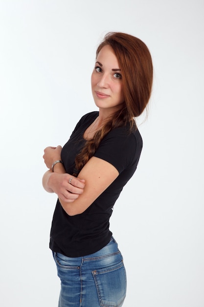 Chica en camiseta y jeans en el fondo blanco