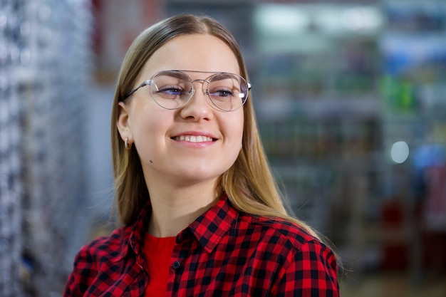 La chica de la camiseta saca y se mide las gafas.