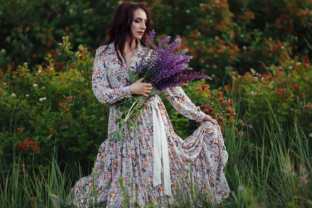 Chica en un campo de flores, con un hermoso vestido