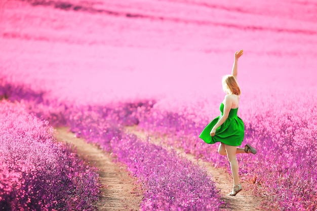 chica en un campo de flores lilas en colores lavanda, paisaje violeta y rosa, feliz y armoniosa