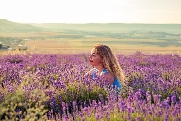 Chica en un campo de lavanda al atardecer. Soleada tarde de verano en Crimea.