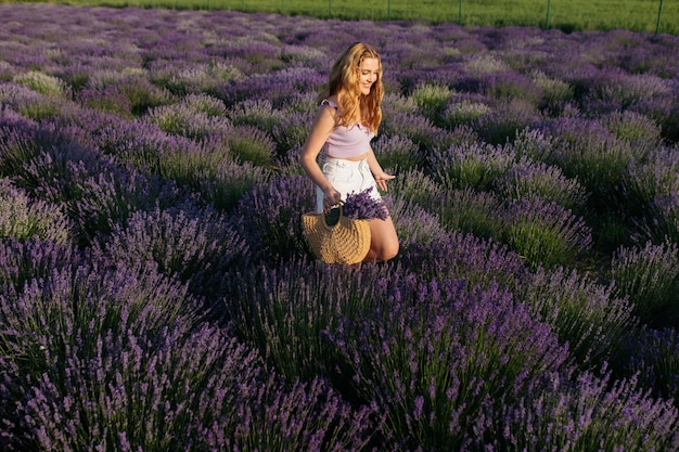 Chica en un campo de lavanda Mujer en un campo de flores de lavanda al atardecer con un vestido blanco Francia Provenza