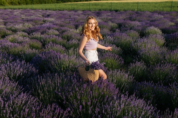 Chica en un campo de lavanda Mujer en un campo de flores de lavanda al atardecer con un vestido blanco Francia Provenza