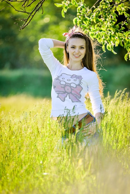 una chica en un campo con un oso en su camisa