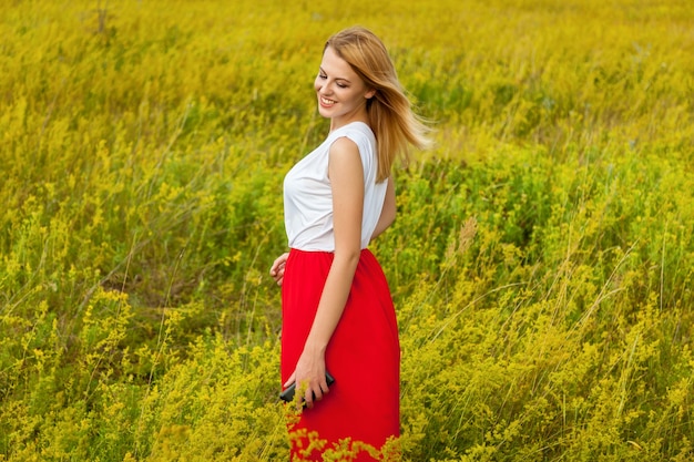 Chica en el campo con un teléfono negro. Chica en el campo con teléfono.