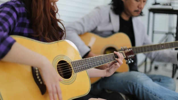 Chica cantando en el micrófono y tocando la guitarra