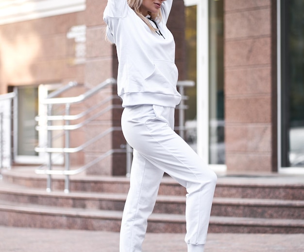 Chica con capucha blanca y pantalones blancos Mockup para diseño