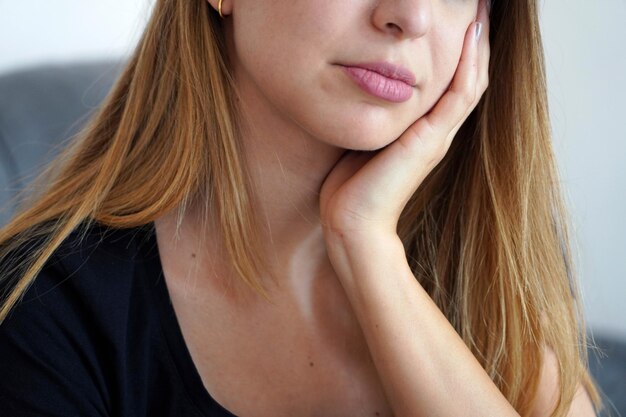 Foto chica con la cara apoyada en la mano dolor de muelas depresión salud mental