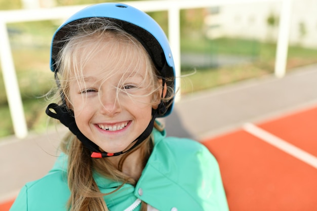 Una chica con casco azul patina en el estadio