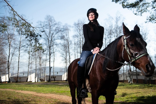 Chica con casco a caballo en el bosque