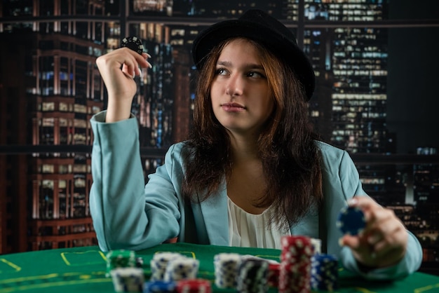 Chica en un casino juega al póquer con la confianza de ganar el juego mujer de póquer con cartas