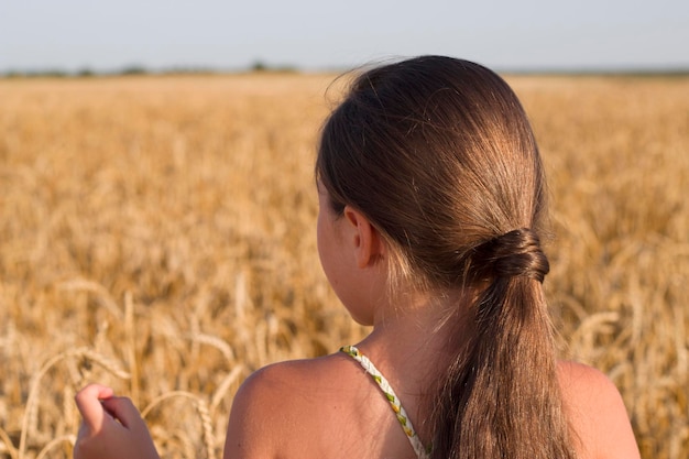 chica caucásica con cabello oscuro en campo de trigo