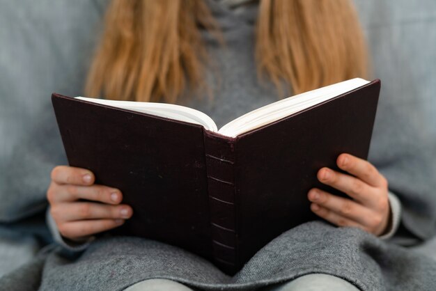 Chica caucásica con cabello rubio leyendo un libro