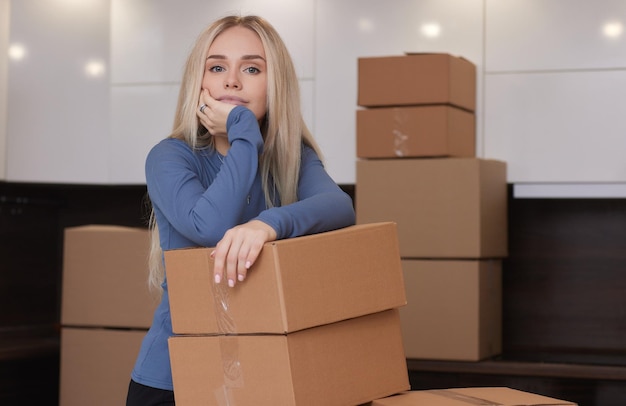 Chica caucásica grabando cajas para mudarse a un nuevo apartamento