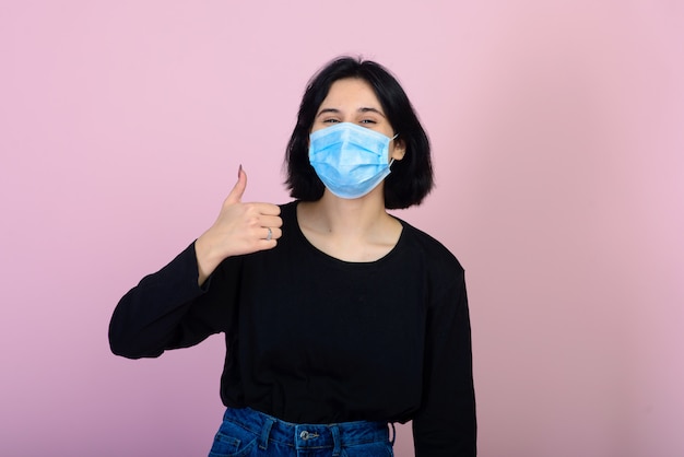 Foto la chica caucásica en mascarilla protectora de color azul. la mujer. retrato de disparo. concepto de protección contra virus y contaminación.