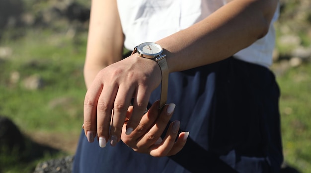 Chica caucásica con un reloj de pulsera en la mano