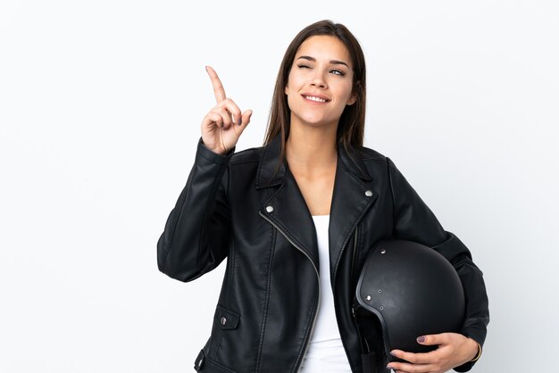 Chica caucásica sosteniendo un casco de motocicleta en blanco apuntando con el dedo índice una gran idea