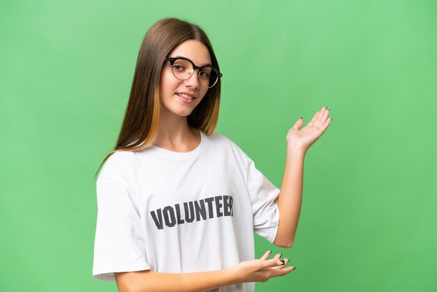 Chica caucásica voluntaria adolescente sobre un fondo aislado extendiendo las manos a un lado para invitar a venir