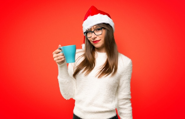 Chica con la celebración de las fiestas navideñas con café caliente en una taza de papel para llevar