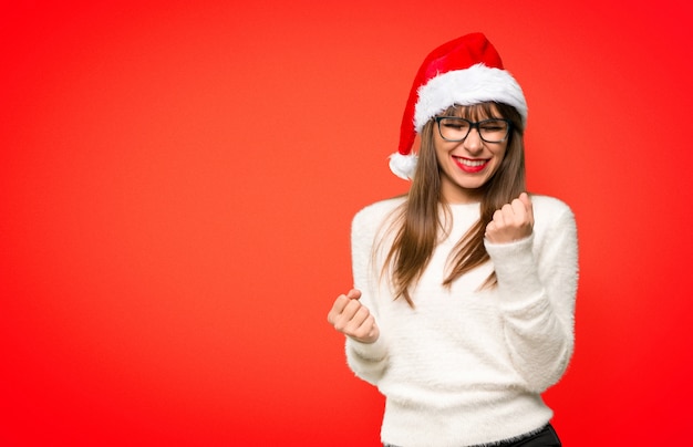 Chica celebrando las fiestas navideñas celebrando una victoria.