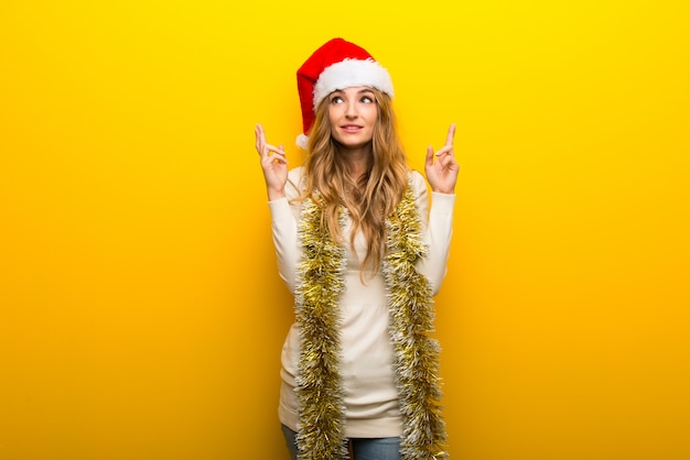 Chica celebrando las vacaciones de navidad sobre fondo amarillo