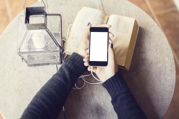 Chica con celular en blanco y libros.