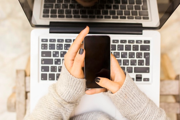 Chica con celular y laptop