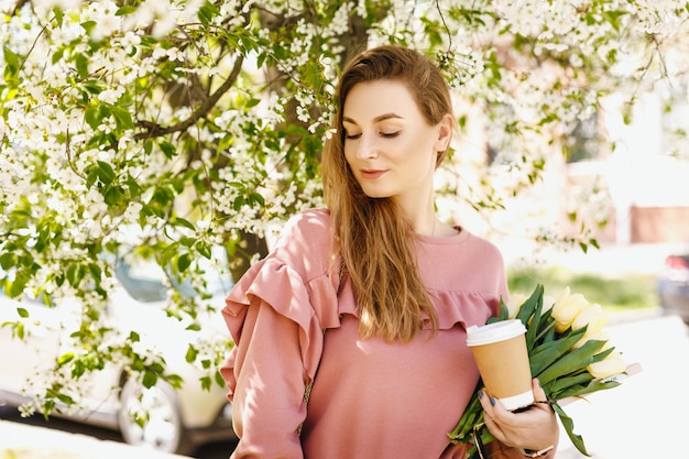 Chica cerca de un árbol floreciente