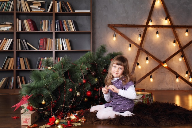 Chica cerca de un árbol de Navidad caído