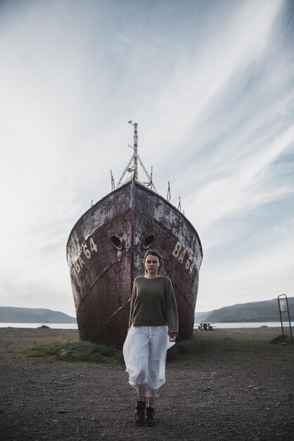 chica cerca del enorme barco en Islandia