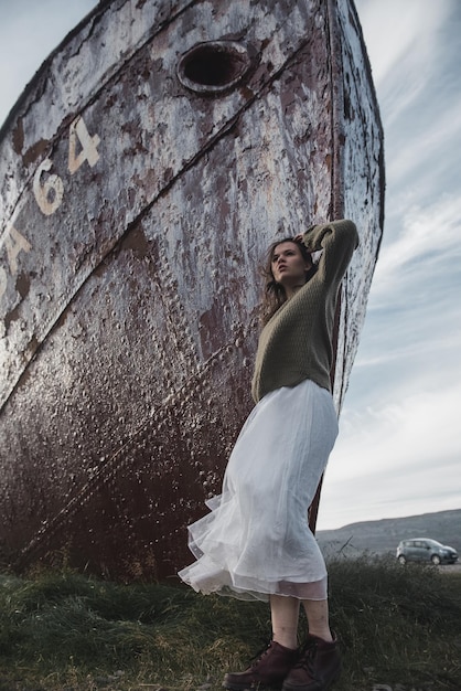Foto chica cerca del enorme barco en islandia