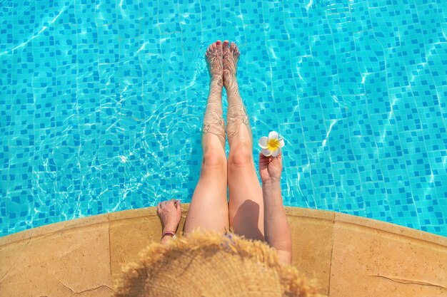 Chica cerca de la piscina con una flor