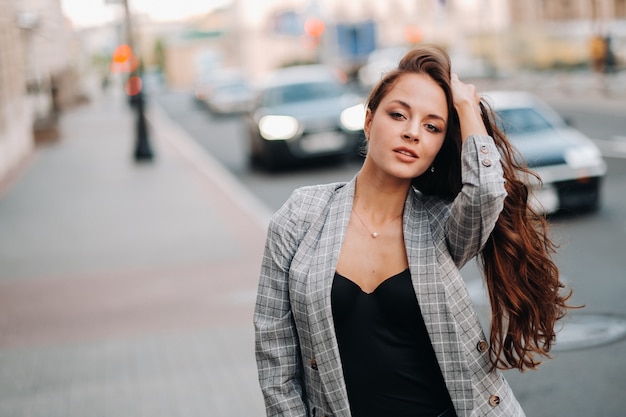 Una chica con chaqueta y cabello largo camina por la ciudad vieja.