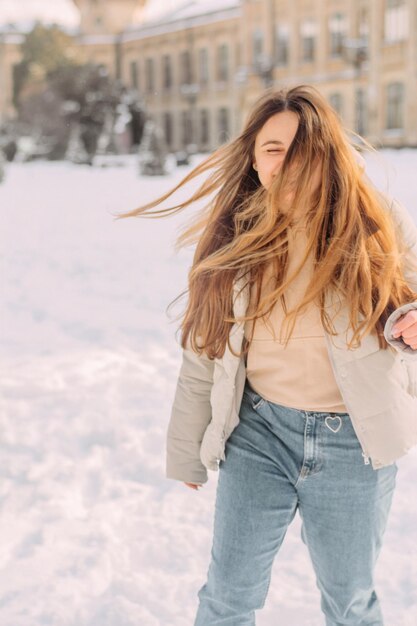 Una chica con una chaqueta pastel dando un paseo en invierno