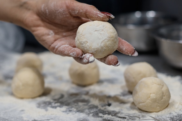 Chica chef preparando masa hace las tartas de queso en la cocina cerca de fondo borroso