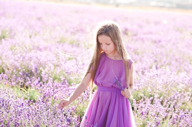 Chica chico rubio posando en la pradera de lavanda