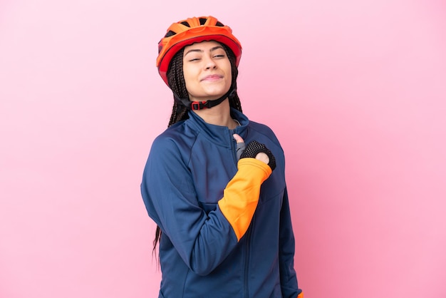 Foto chica ciclista adolescente aislada sobre fondo rosa orgulloso y satisfecho de sí mismo