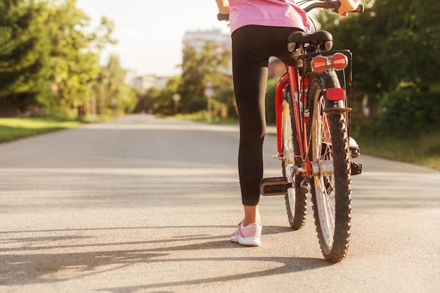 Chica ciclista en pista de asfalto Niño montando en bicicleta en verano