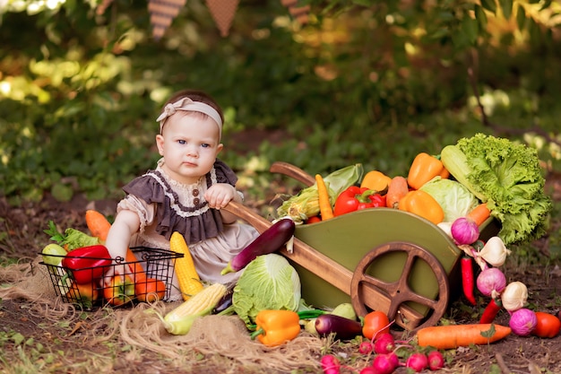 Chica cocina una ensalada de verduras en la naturaleza. El jardinero recoge una cosecha de verduras. Entrega de productos