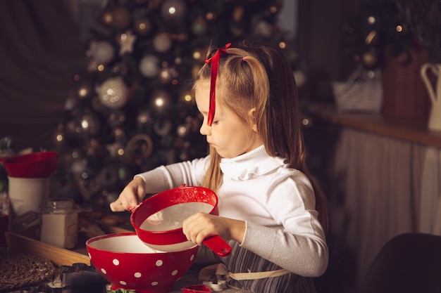 La chica de la cocina está preparando galletas. Adornos navideños, tradiciones familiares, comida navideña, vísperas de vacaciones.