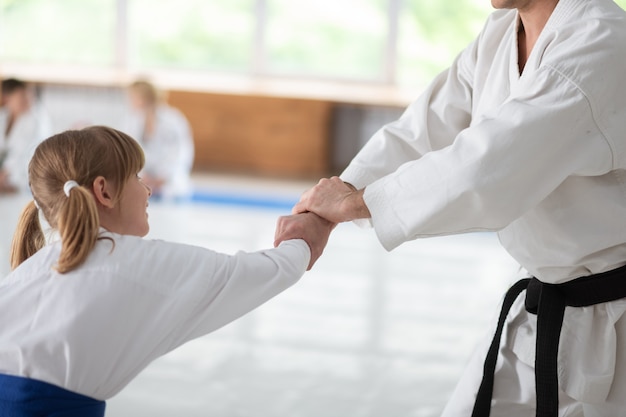 Chica con coletas. Linda chica con coletas preparándose para la competición deportiva practicando aikido