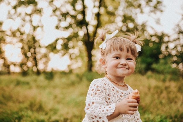 Chica comiendo croissant en el bosque