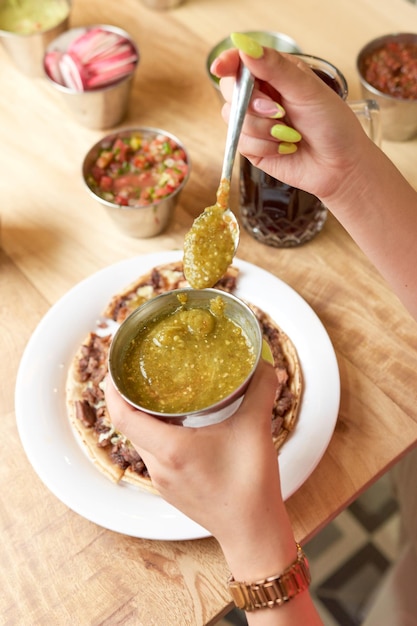 Foto chica comiendo deliciosa comida típica mexicana tacos sopes pastor etc