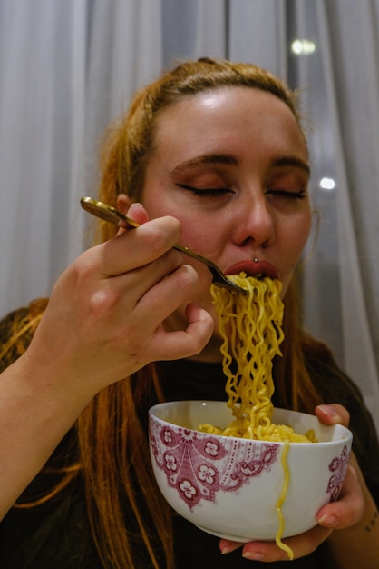 Foto chica comiendo fideos asiáticos