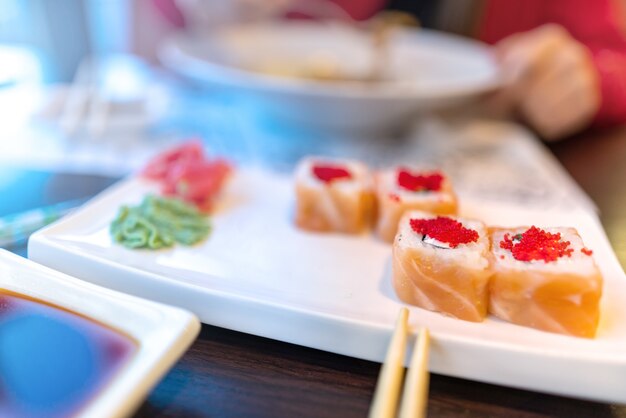 Chica comiendo pasta y sushi borroso sin una cara almuerzo en el restaurante sushi Philadelphia