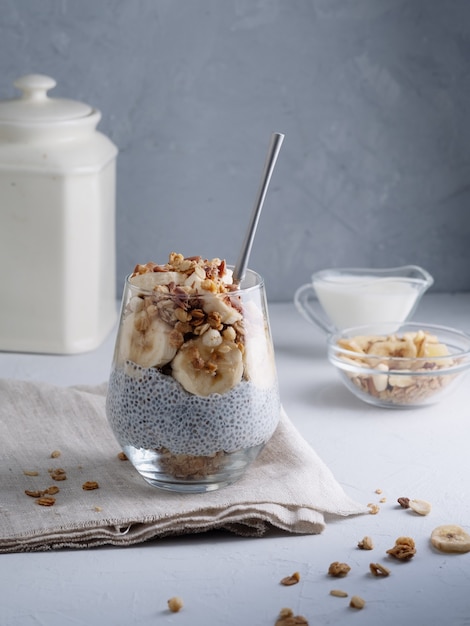 Chica comiendo pudín de chía con leche de coco, plátano, nuez, semillas de chio, granola, snack saludable o br