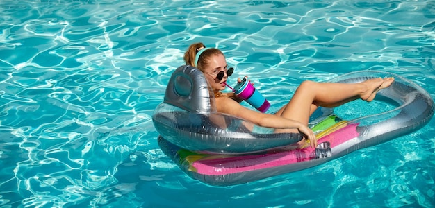 Chica de concepto de vacaciones en colchón inflable día caluroso de verano resort con piscina